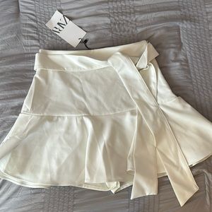 Off-white skirt, has shorts built into the skirt, zips up on the side.